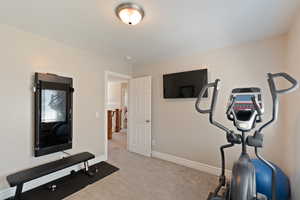 Exercise area with carpet floors and baseboards