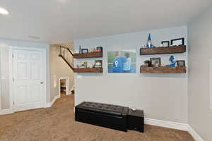 Hall with carpet floors, stairway, and baseboards
