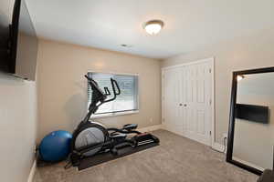 Workout room with carpet flooring and baseboards