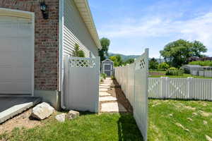 View of property exterior featuring brick siding, an outbuilding, and a mountain view
