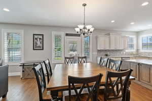 Dining area with a chandelier, recessed lighting, light wood finished floors, and baseboards