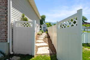 View of side of home with a mountain view and a gate
