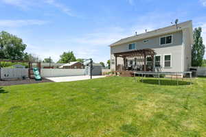 Rear view of house featuring a pergola, a trampoline, a playground, and a patio