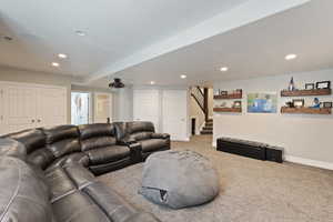 Living room featuring carpet, recessed lighting, baseboards, and stairway