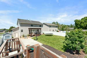 Back of house with a trampoline, a deck, and a residential view