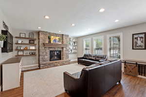 Living area with wood finished floors, a fireplace, recessed lighting, and baseboards