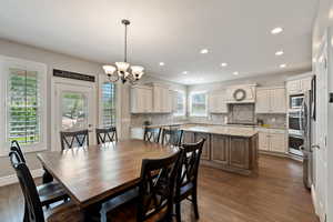 Dining space featuring dark wood finished floors, recessed lighting, and a chandelier