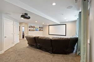 Carpeted cinema with recessed lighting and a dry bar