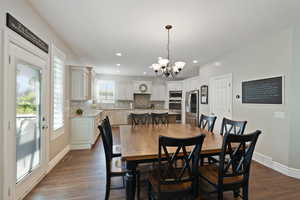 Dining space featuring a chandelier, dark wood-type flooring, recessed lighting, and baseboards