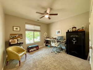 Carpeted office featuring a ceiling fan and baseboards