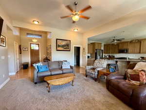 Living area with ceiling fan, light carpet, and baseboards