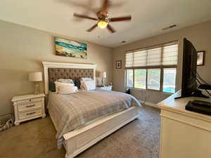 Carpeted bedroom with baseboards and a ceiling fan