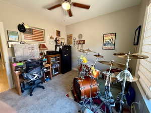 Carpeted office space with a ceiling fan