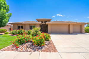 Prairie-style house featuring an attached garage, driveway, stucco siding, and a tiled roof