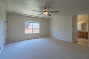 Spare room with a ceiling fan, baseboards, and light carpet