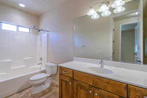 Full bathroom featuring toilet, shower / washtub combination, vanity, tile patterned floors, and baseboards