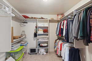 Spacious walk in closet with built in shelves and racks