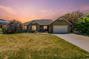 View of front of home featuring board and batten siding, concrete driveway, an attached garage, and a lawn