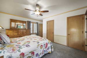 Carpeted bedroom featuring a ceiling fan