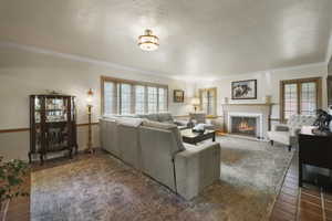Living room with crown molding, a brick fireplace, and baseboards