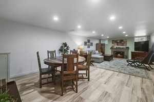 Dining area featuring a fireplace, recessed lighting, and light wood finished floors