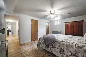 Bedroom featuring light wood-style floors, ceiling fan, and baseboards