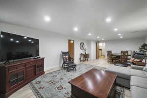 Living area with recessed lighting, light wood finished floors, and baseboards