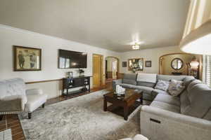 Tiled living area with arched walkways and crown molding
