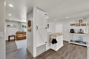 Hallway with dark wood-type flooring, recessed lighting, and baseboards