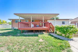 Back of house featuring brick siding and a deck