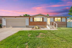 Ranch-style home featuring brick siding, an attached garage, and concrete driveway
