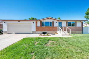 Single story home with an attached garage, brick siding, and concrete driveway