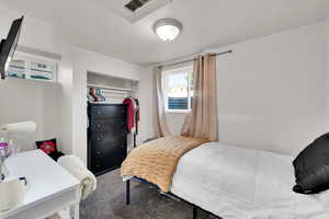 Carpeted bedroom with a closet