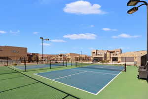 View of tennis court with a residential view and community basketball court