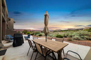Patio terrace at dusk with outdoor dining area, a patio area, and a mountain view