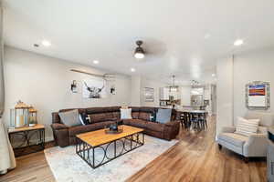 Living room featuring light wood-style floors, ceiling fan, recessed lighting, and baseboards
