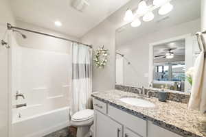 Ensuite bathroom with shower / bath combo, vanity, toilet, and ceiling fan