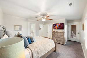 Carpeted bedroom with a ceiling fan and ensuite bathroom