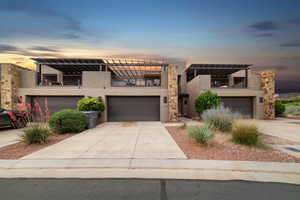 Contemporary house featuring a balcony, stucco siding, concrete driveway, an attached garage, and a pergola