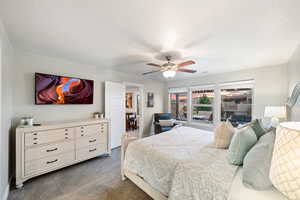 Bedroom with dark carpet and a ceiling fan
