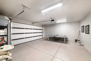 Garage with baseboards and a garage door opener