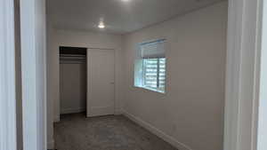 Unfurnished bedroom featuring carpet, baseboards, and a closet