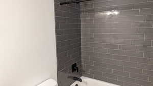 Full bathroom with toilet and shower / washtub combination