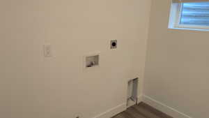Laundry room with hookup for an electric dryer, washer hookup, dark wood-style floors, and baseboards