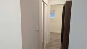 Hall with light wood finished floors and baseboards