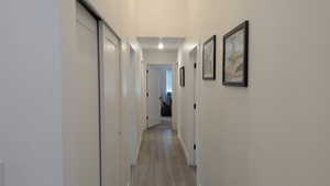 Hallway featuring light wood-type flooring and baseboards