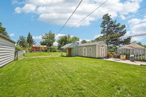 View of yard with an outdoor shedstructure and a patio