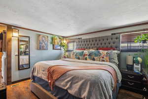 Bedroom featuring wood finished floors, ornamental molding, and baseboards