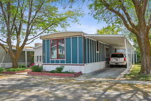 Manufactured / mobile home with driveway and an attached carport