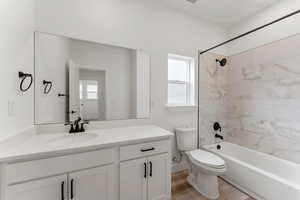 Bathroom featuring toilet, vanity, tub / shower combination, and LVP finished floors